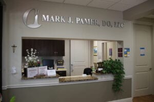 A reception area with “MARK J. PAMER, DO, LLC” on the wall