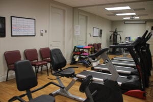 A gym room with equipment and chairs