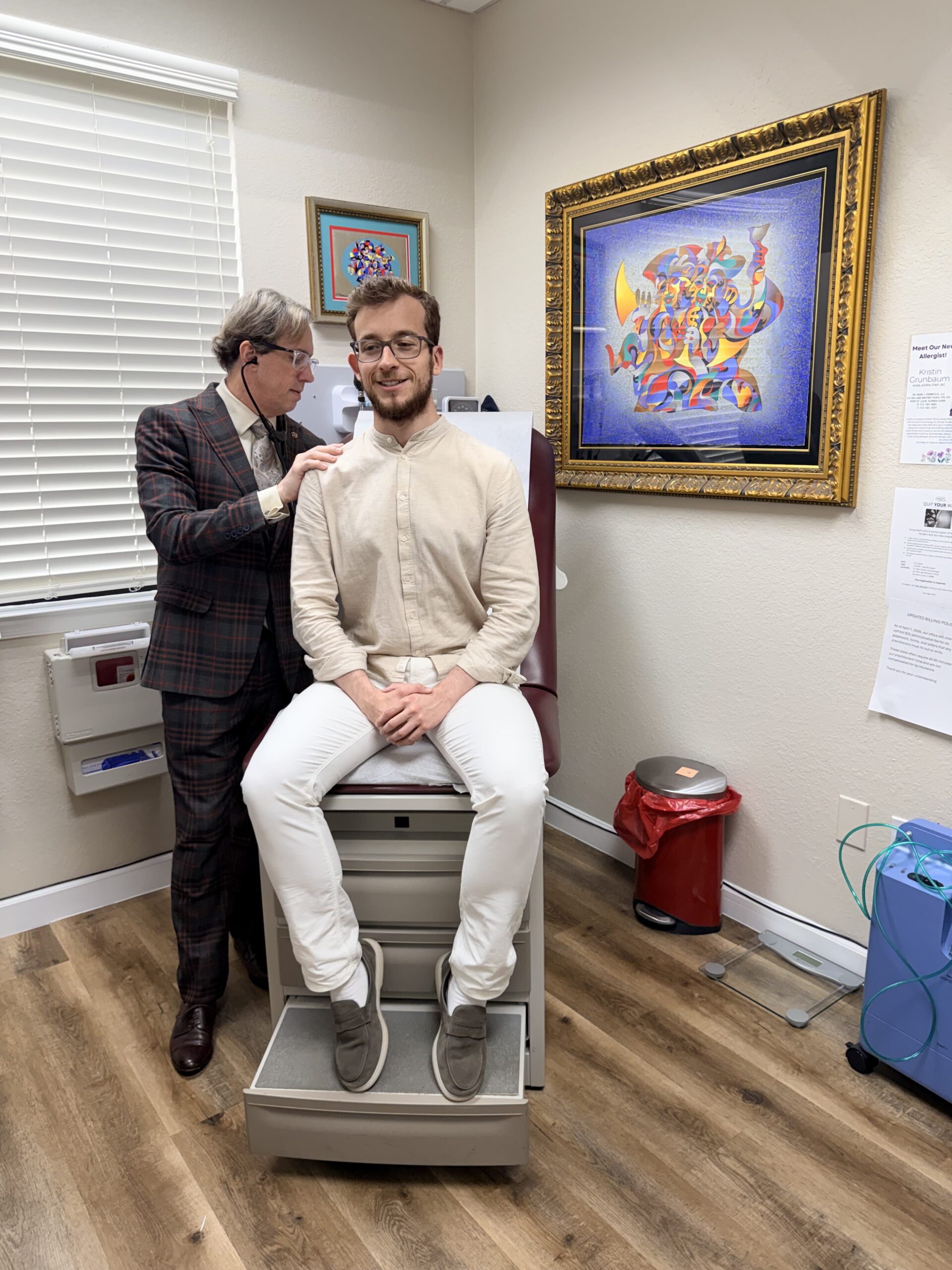 A man receives an ear examination from a healthcare professional in a clinic.