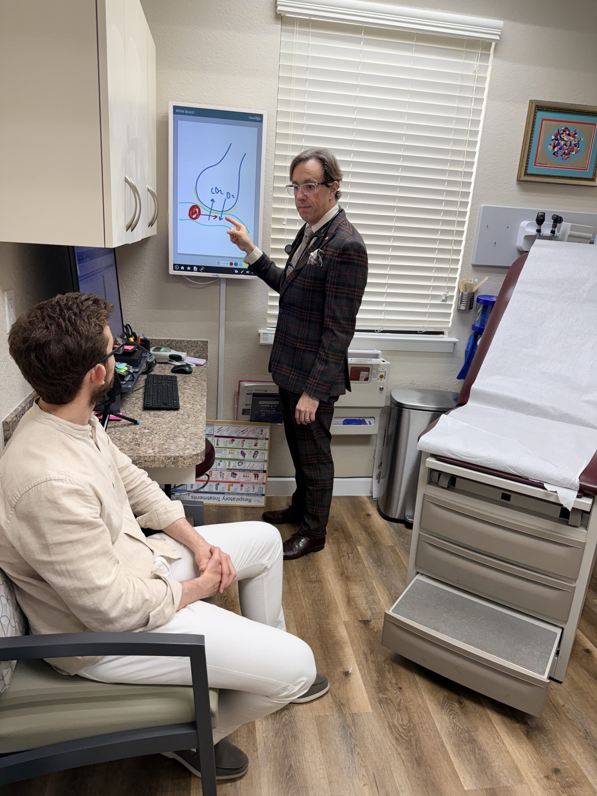 Doctor explaining medical images to a patient in a consultation room.
