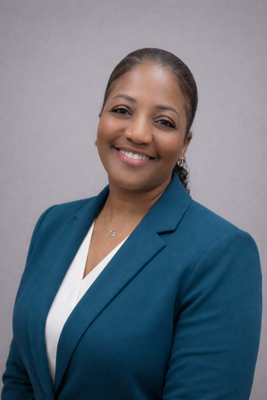 Professional woman smiling confidently in a teal blazer.