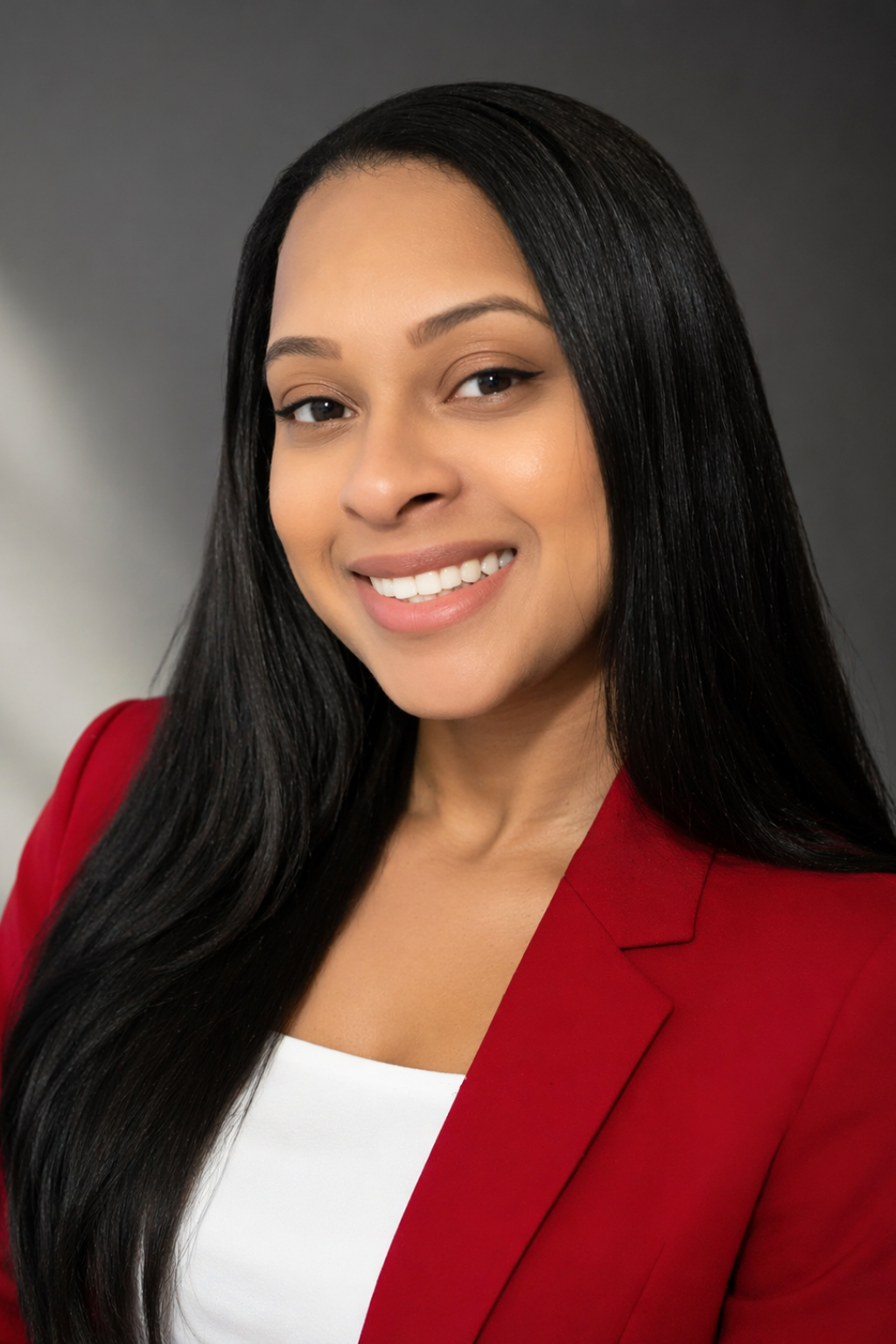 Smiling woman in a red blazer and white top.